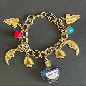 Elegant gold tone moon, leaf, Paris perfume bottle charm bracelet.